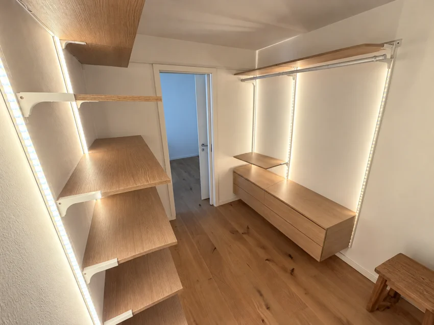 Dressing vide avec étagères en bois, penderies, tiroirs et éclairage