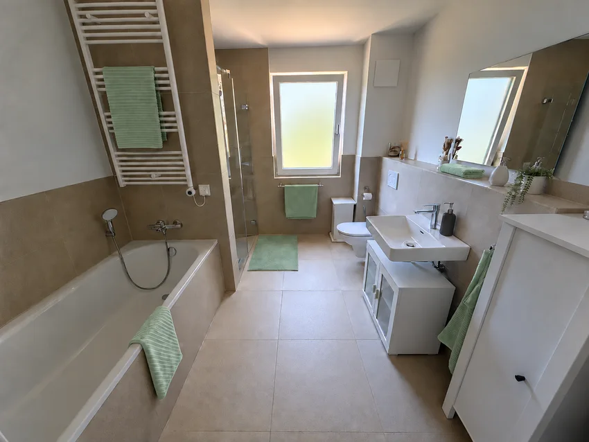 Salle de bains avec lumière naturelle, baignoire, douche séparée et lavabo