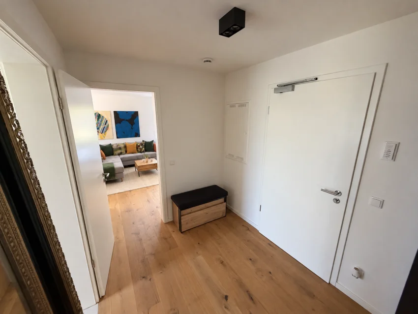 Entrée avec banc, porte d’entrée et vue sur le séjour